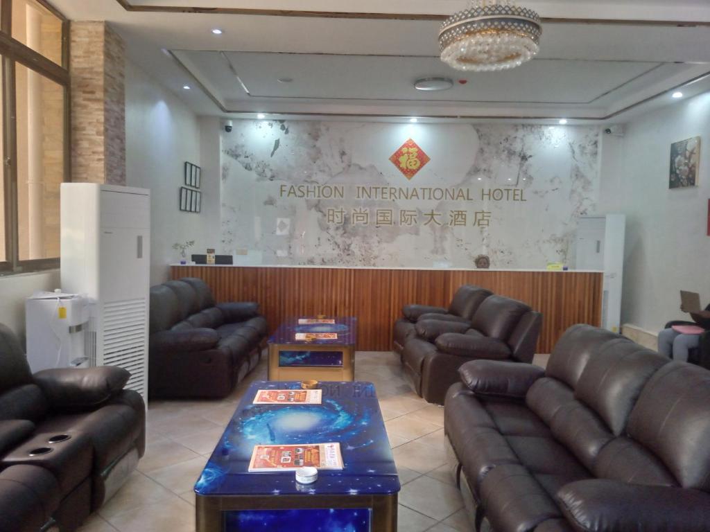 uma sala de espera com sofás de couro e uma placa em FASHION INTERNATIONAL HOTEL em Dar es Salaam