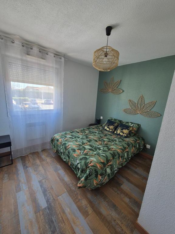 1 dormitorio con cama y pared verde en appart cosy proche zone aéronautique, en Tournefeuille