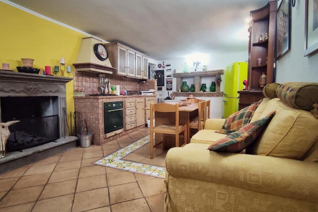 a living room with a couch and a table and a kitchen at La casa nel Borgo in San Gregorio da Sassola