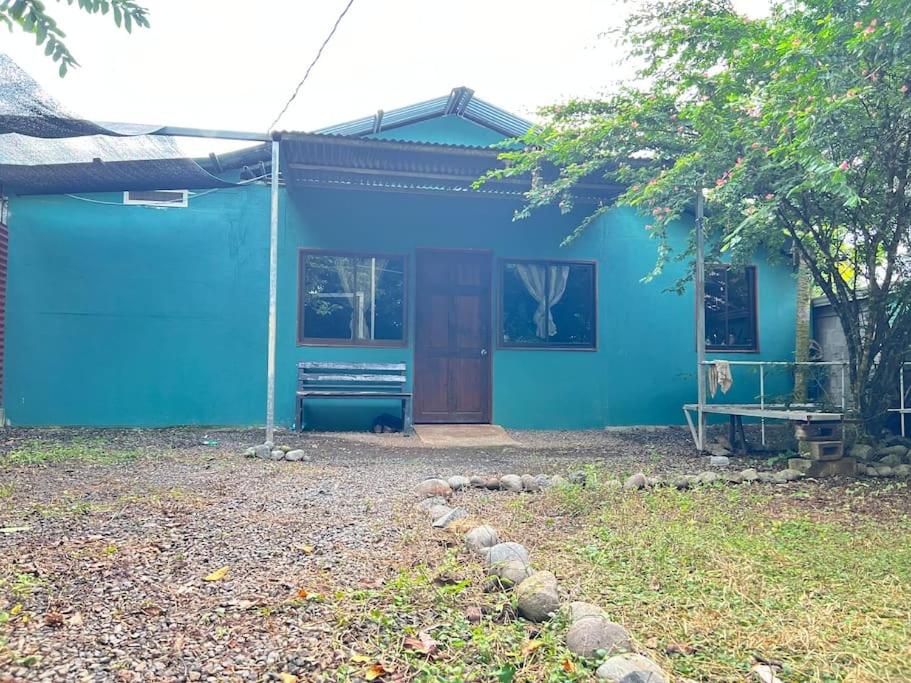 una casa azul con un perro sentado frente a ella en Santa Teresa, Montezuma,Tambor,Cobano, en Cóbano