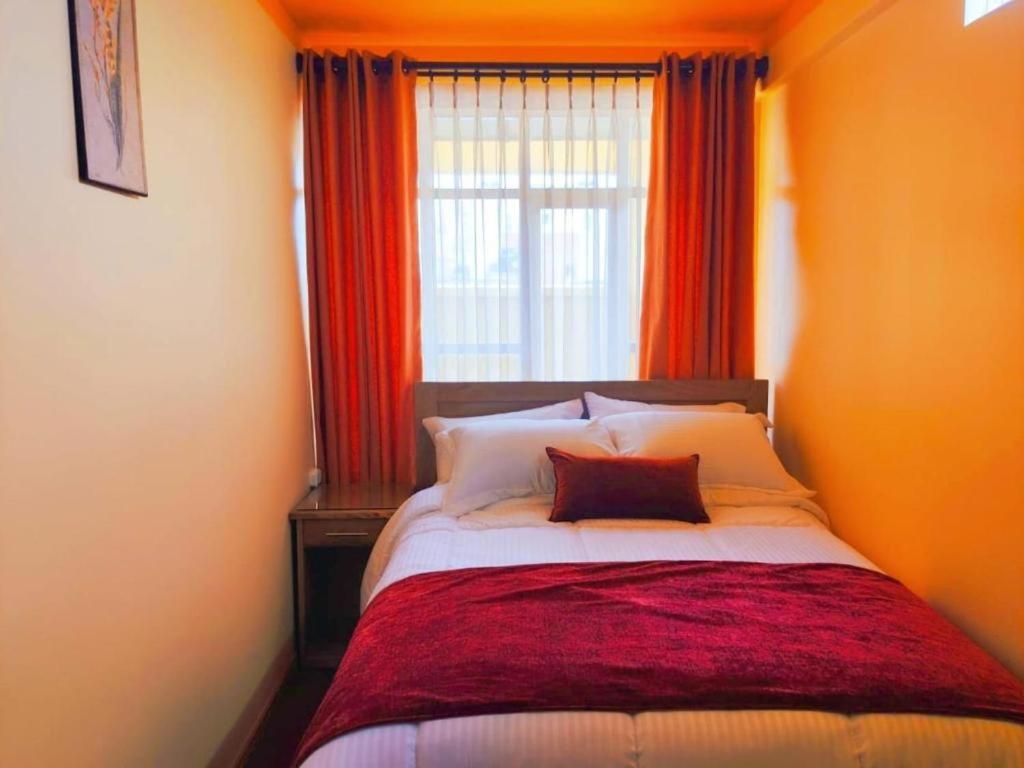 a bedroom with a large bed with a window at COMODORO DEPARTAMENTOS in Oruro