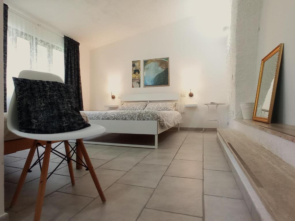 1 dormitorio con 1 cama y 1 silla en Gli Archi Country Home, en Giurdignano
