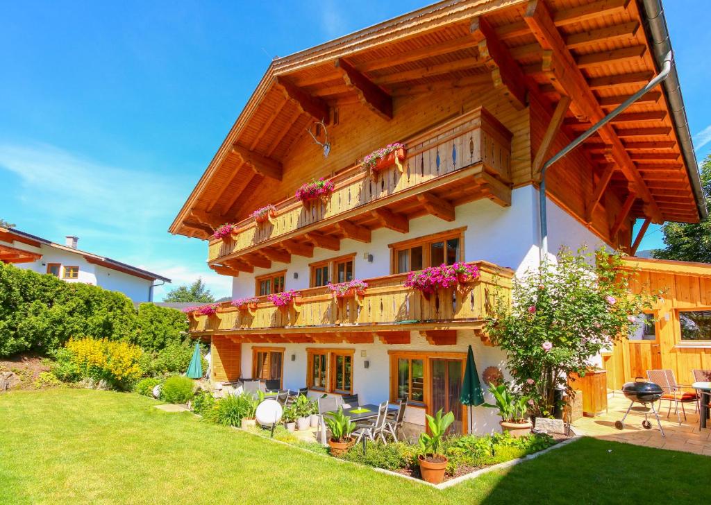 a large wooden house with a balcony at Haus Berge Appartements in Wagrain