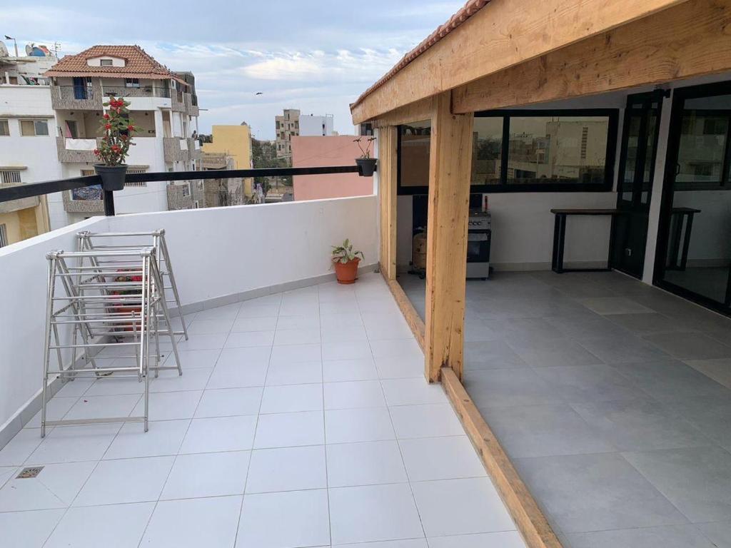 a balcony with a metal ladder on top of a building at Résidence Kali in Guediawaye