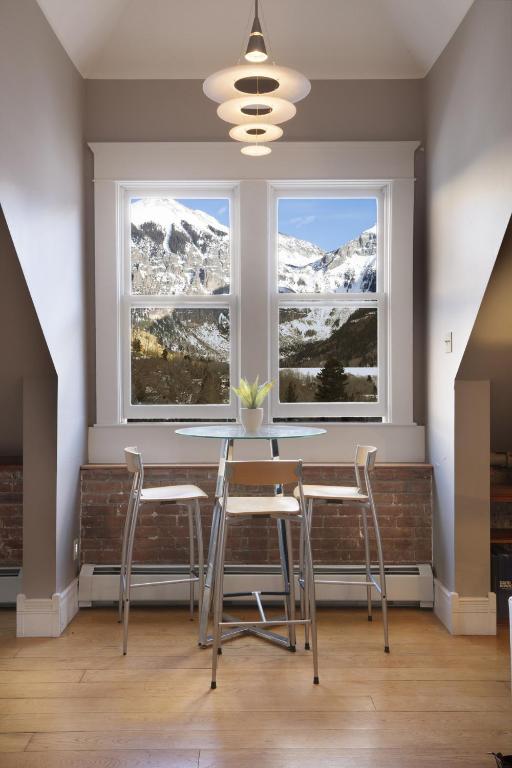 a table and chairs in front of a window with snow covered mountains at Ajax Loft apts in Telluride