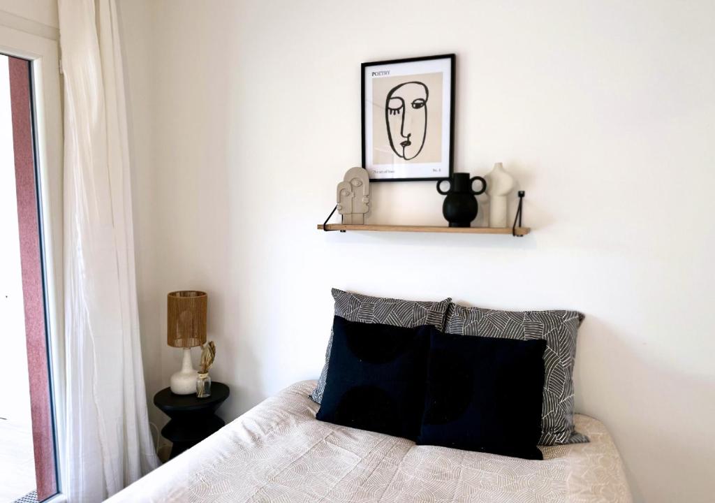 une chambre avec un lit avec un tableau sur le mur dans l'établissement Studio Biscawaï II, à Biscarrosse