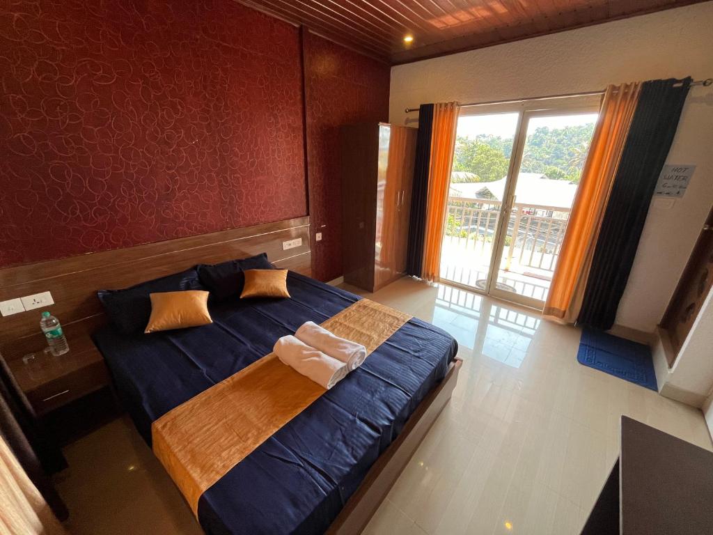 1 dormitorio con cama con sábanas azules y ventana en Hill side Home en Anachal