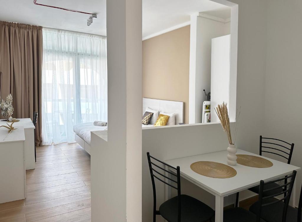 a white room with a table and chairs and a bedroom at Miami Apartments in St Julian's