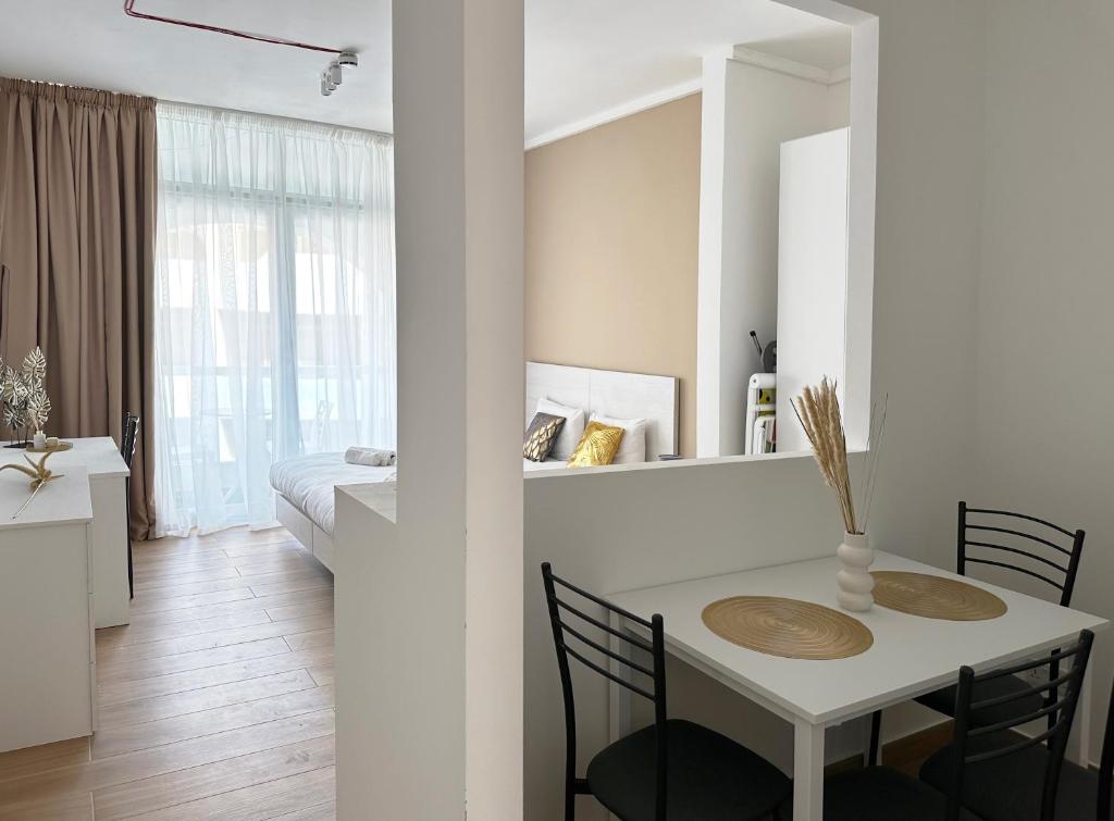 a white room with a table and chairs and a bedroom at Miami Apartments in St. Julianʼs