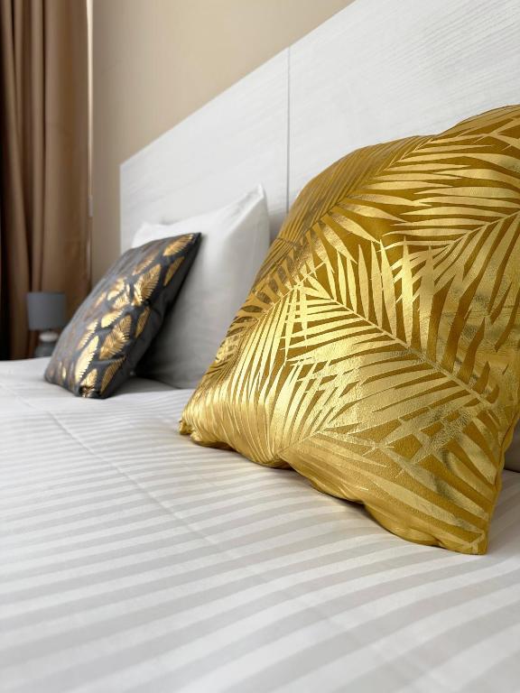 a bed with two yellow pillows on top of it at Miami Apartments in St. Julianʼs