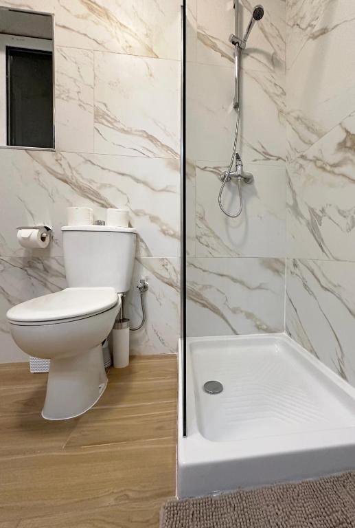 a white bathroom with a toilet and a shower at Miami Apartments in St. Julianʼs