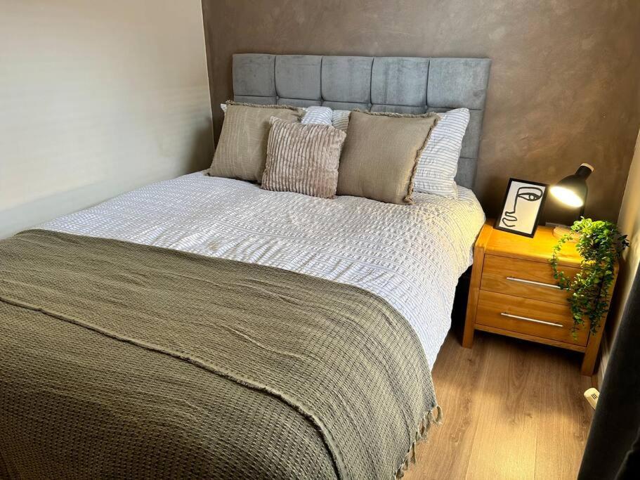 a large bed in a bedroom with a night stand at Auckland House 3 beds free parking in Doncaster