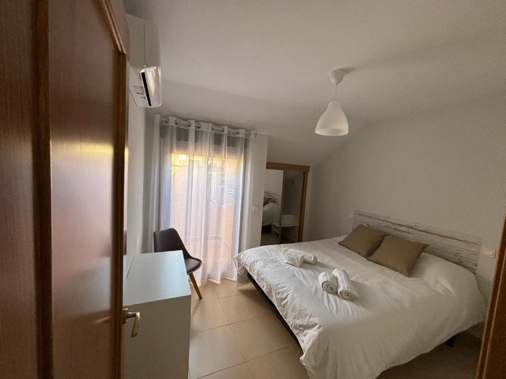 a bedroom with a white bed and a window at Duplex entre molinos in Consuegra