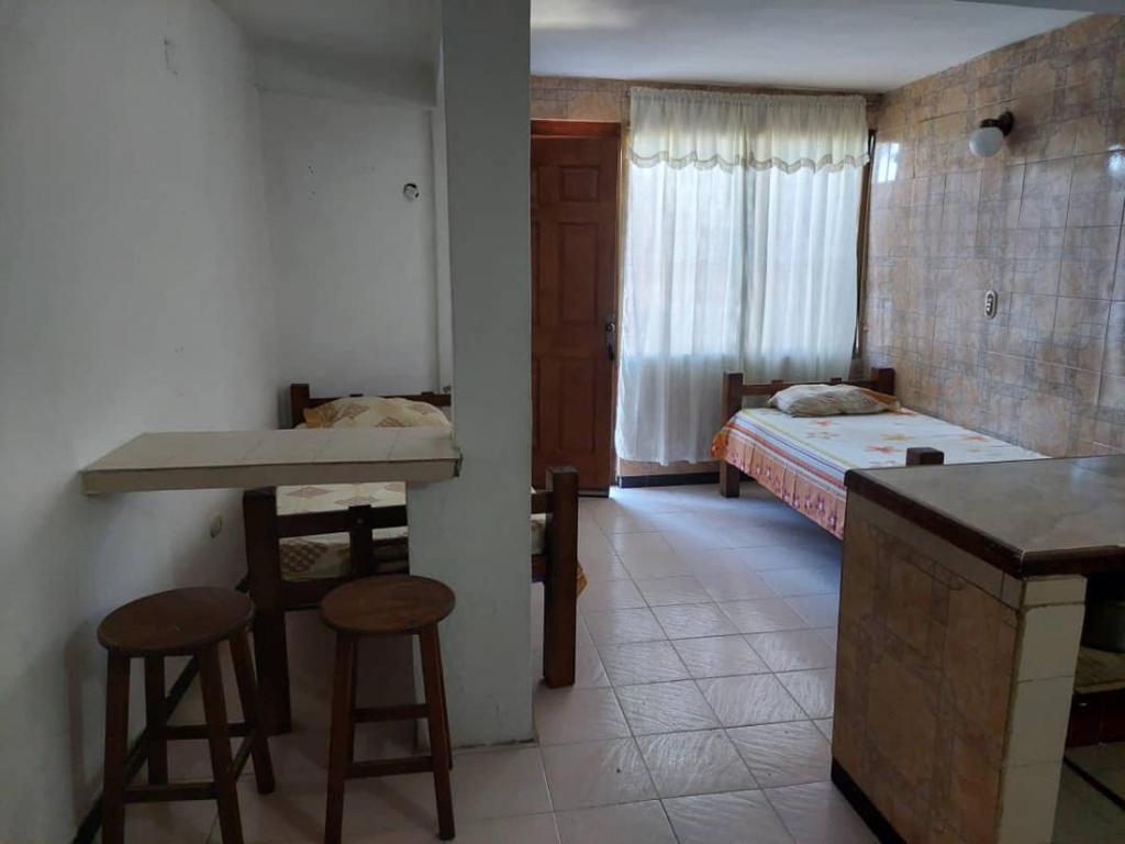 a room with a bedroom with a bed and a kitchen at Alojamientos Nazareth in Catia La Mar