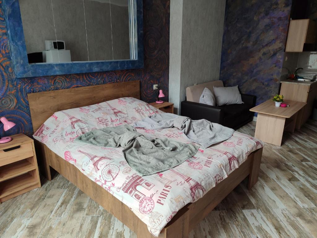a bedroom with a large bed and a mirror at АРТ 3 in Sliven