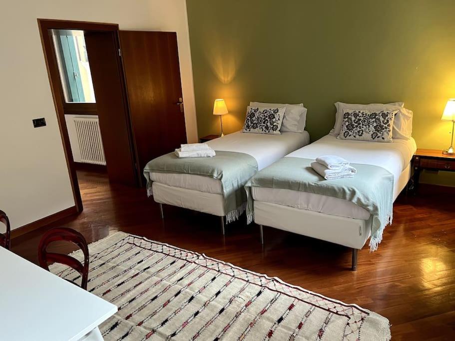 a room with two twin beds and a rug at Il Portico. Charm apartment, Vicenza downtown. in Vicenza