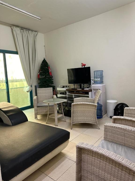 een woonkamer met een bed en een kerstboom bij Private Guest Room w Pool in Sharjah