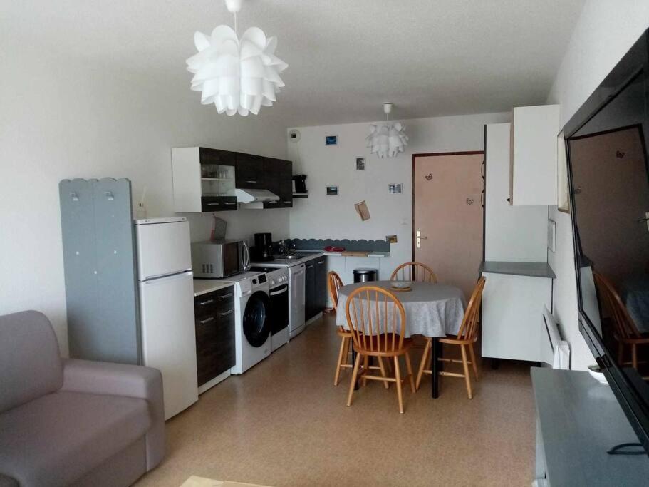 una pequeña cocina con mesa y sillas en una habitación en Vacances Xonrupt-Gerardmer, en Xonrupt-Longemer