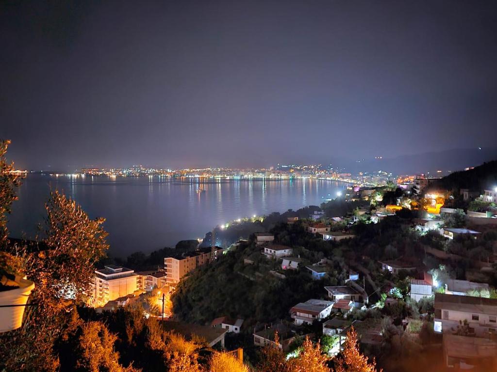 a view of a city at night with the water at Mesaiz 2 in Vlorë