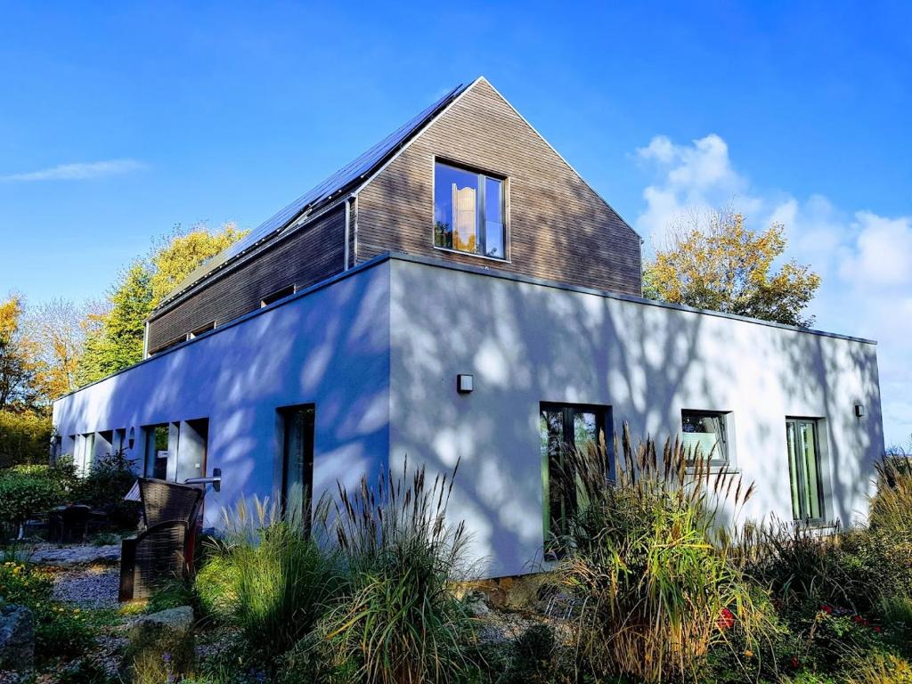 ein weißes Haus mit schwarzem Dach in der Unterkunft Beltblick in Fehmarn