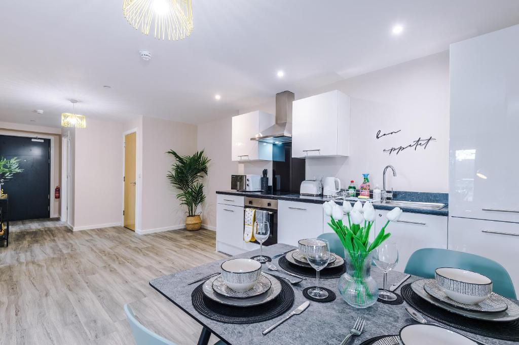 a kitchen and dining room with a table and chairs at The Belfry - Deluxe 2 Bedroom 2 Bathroom Apartment in Manchester