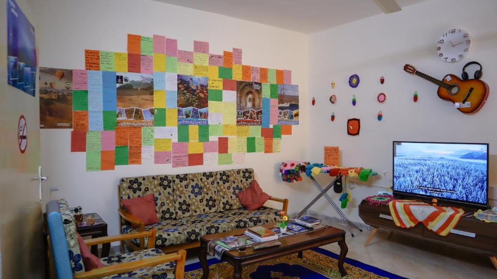 een woonkamer met een bank en een flatscreen-tv bij Extra Experiment in Aqaba