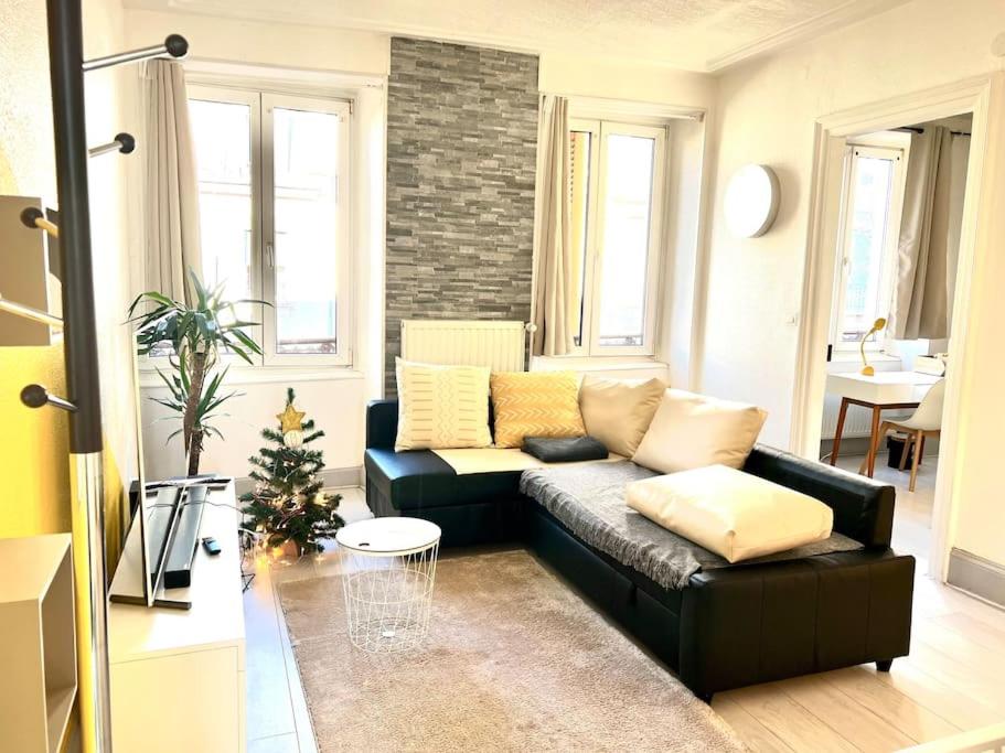 a living room with a couch and a christmas tree at Lumière Secrète Mulhouse Centre Parking Tram in Mulhouse