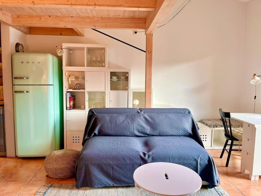 Sala de estar con cama azul y mesa en Apartamento Les Orenetes, en Espinelvas