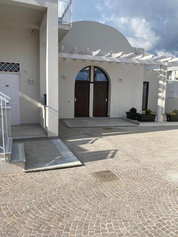 a white building with two brown doors on it at Donna Cuncetta Casa Vacanza Monte di Procida in Monte di Procida