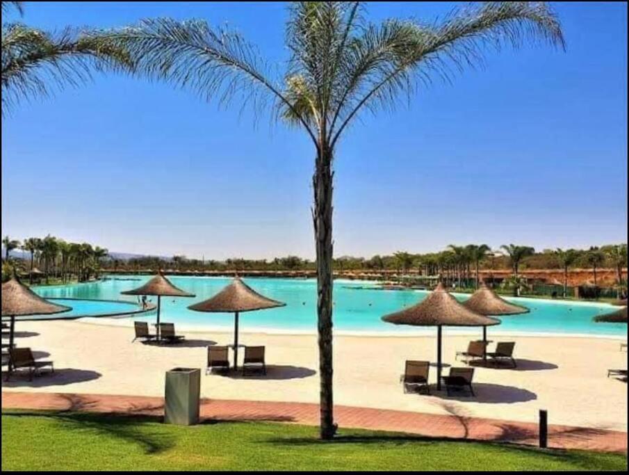 una playa con sillas y sombrillas y una piscina en Cosy luxurious apartment, en Pretoria