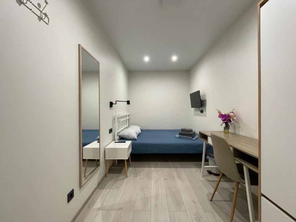 Schlafzimmer mit einem Bett, einem Schreibtisch und einem Spiegel in der Unterkunft Sweet Home in Dnipro