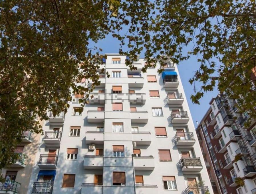 un gran edificio de apartamentos blanco con ventanas en small panoramic flat in milan, en Milán