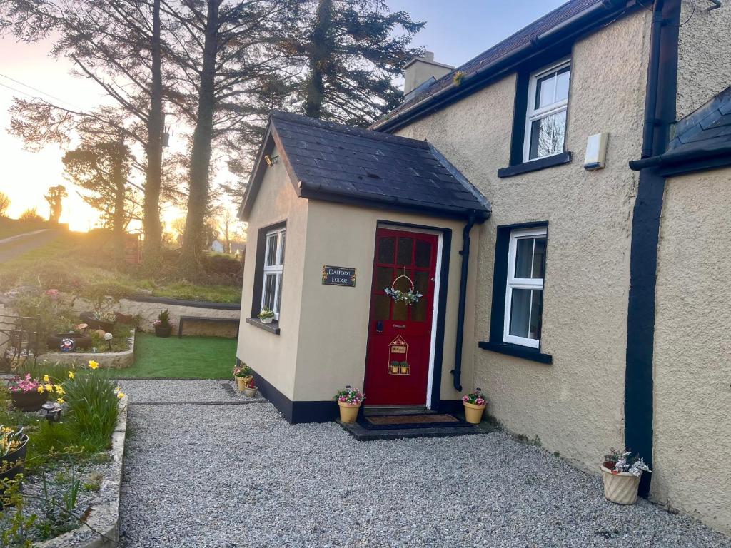 uma casa com uma porta vermelha e um quintal em Daffodil Lodge em Sligo