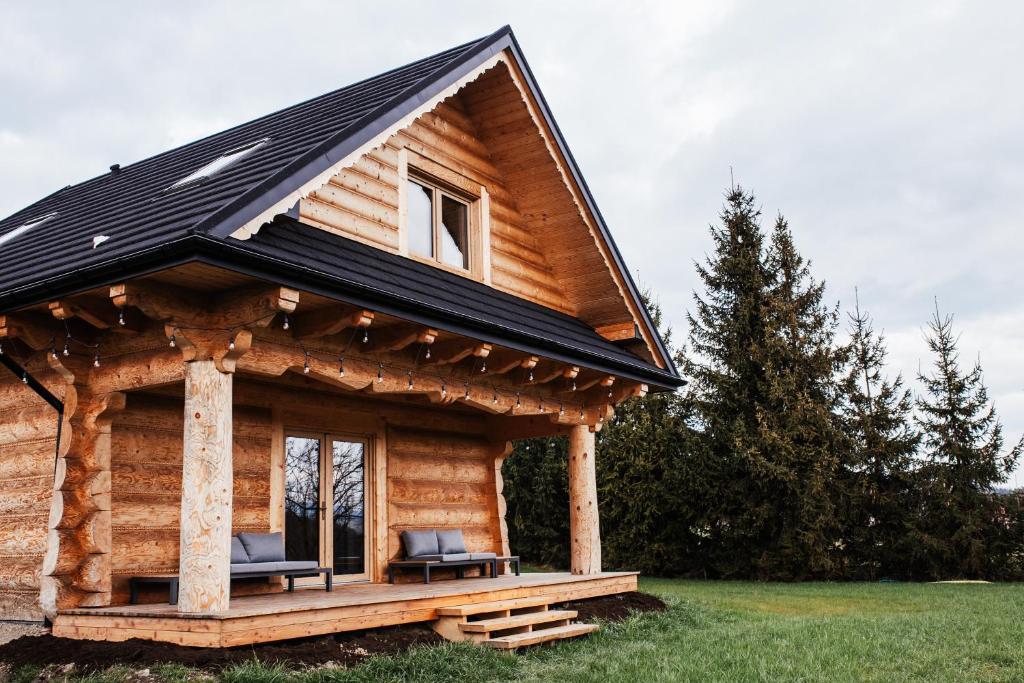 a log cabin with two chairs on the porch at Domek przy szlaku in Rabka-Zdroj