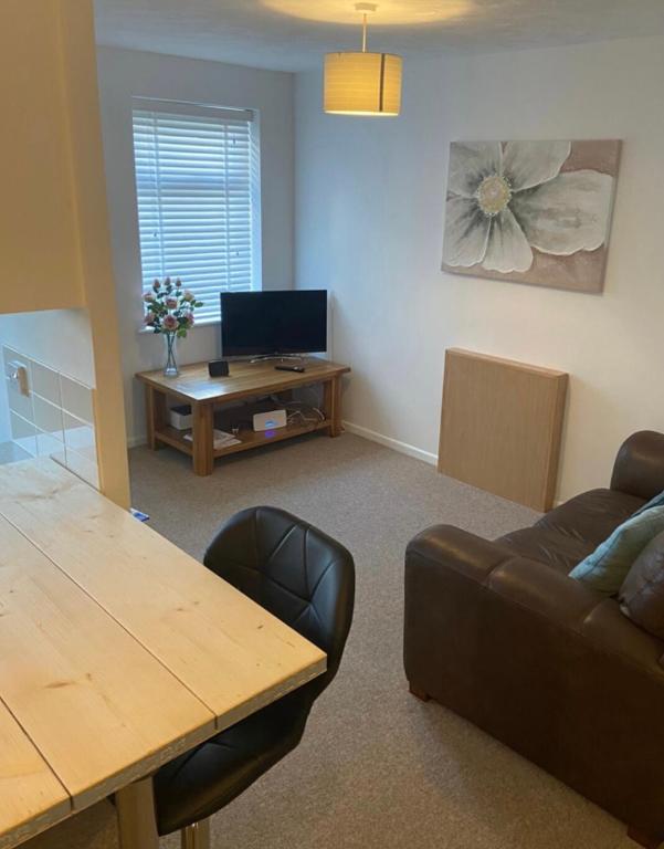 a living room with a table and a couch at One bedroom ground floor flat central Chichester in Chichester
