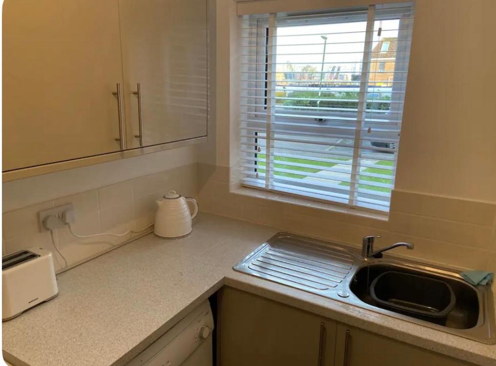 a kitchen counter with a sink and a window at One bedroom ground floor flat central Chichester in Chichester