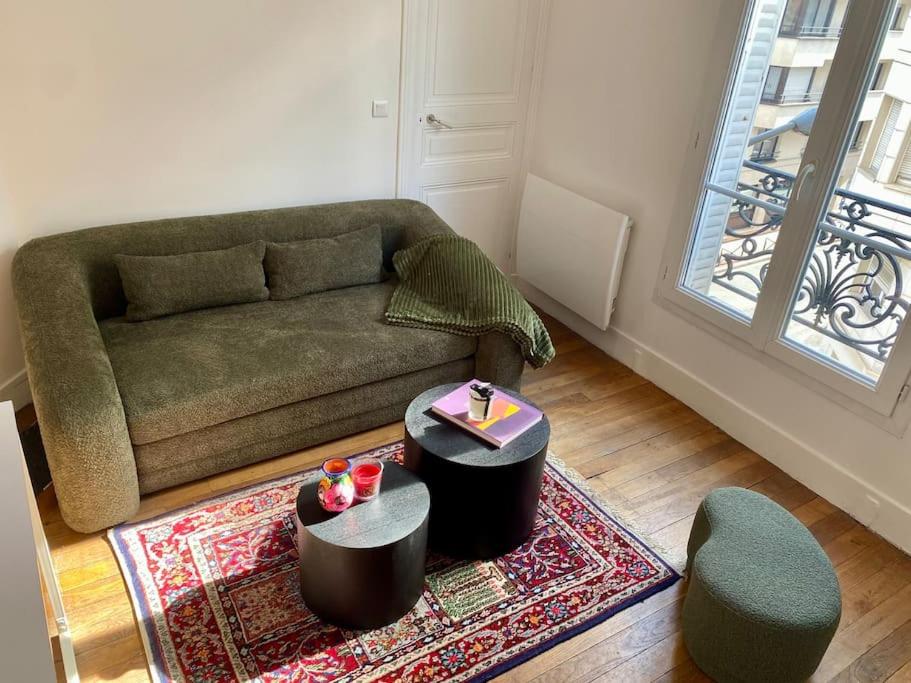 sala de estar con sofá y alfombra en Appartement cozy - Centre ville - 10 min Paris, en Levallois-Perret