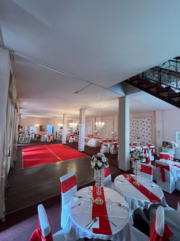 a banquet hall with white tables and chairs and a red carpet at Vila Restaurant Sofia in Marghita
