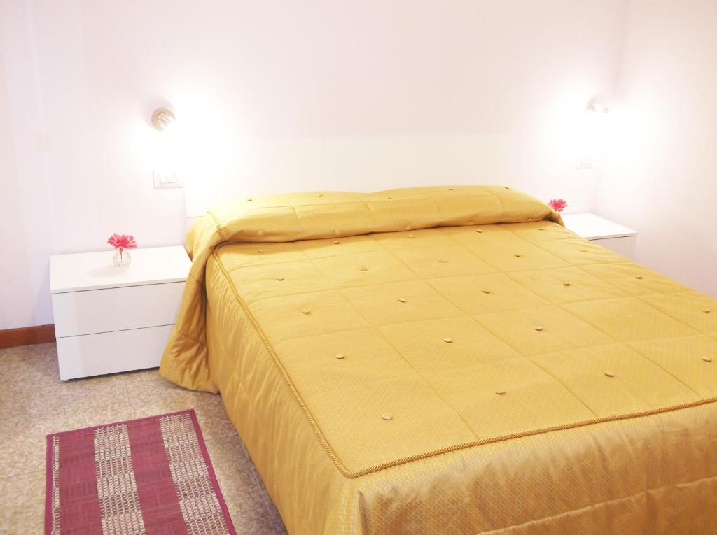 een bed met een geel dekbed in een slaapkamer bij Casa Vacanze Sabrina in Polpenazze del Garda
