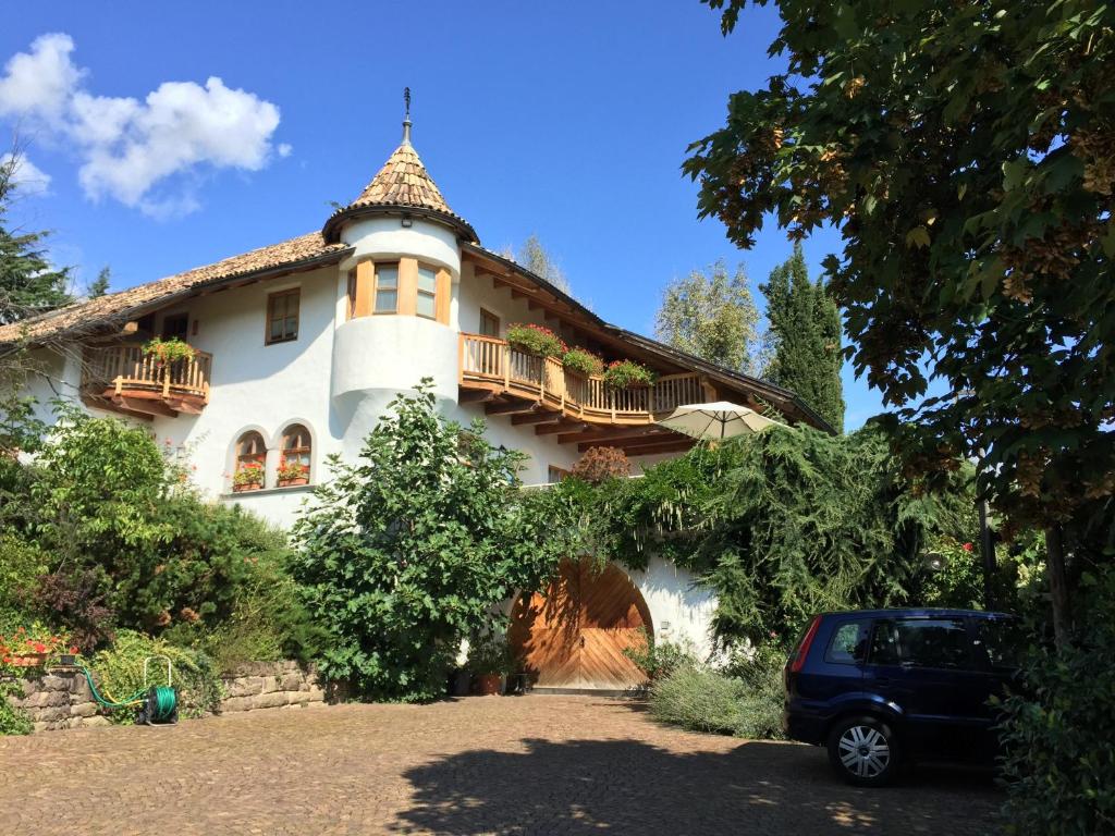 un gran edificio blanco con balcón. en Platzlhof, en Appiano sulla Strada del Vino