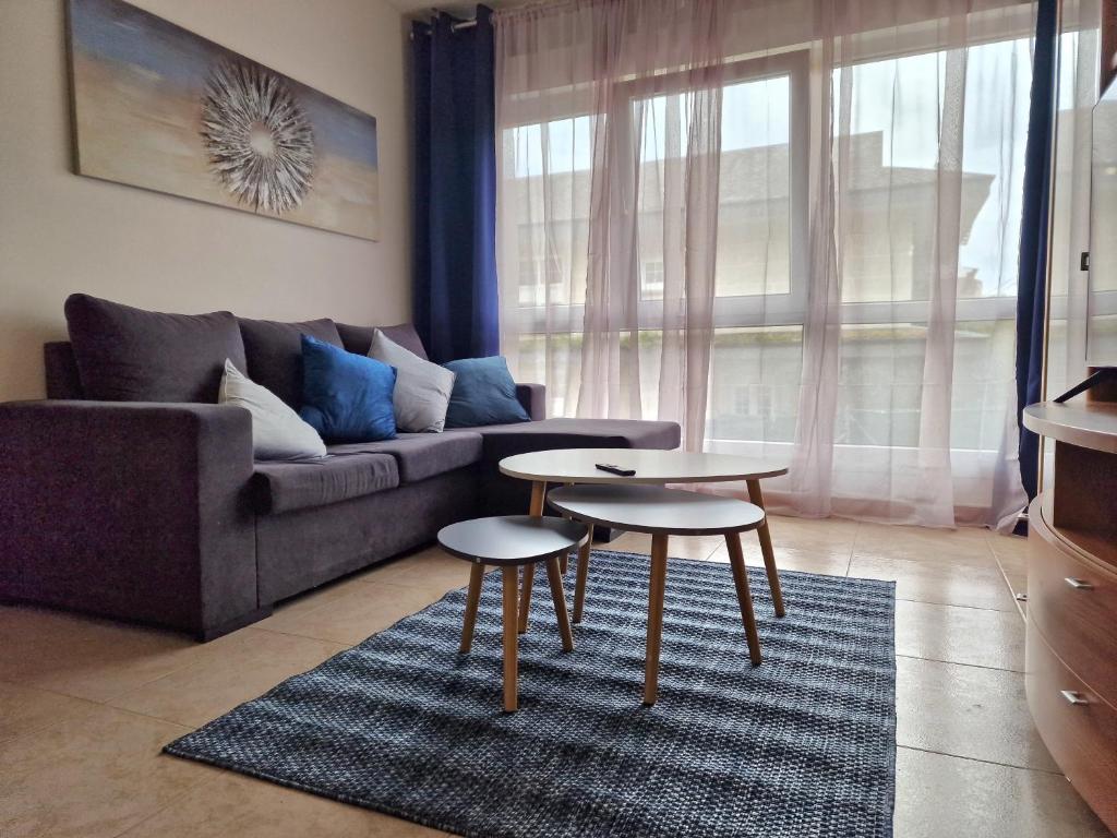 ein Wohnzimmer mit einem Sofa und 2 Tischen in der Unterkunft Lovely Blue Moaña in Moaña