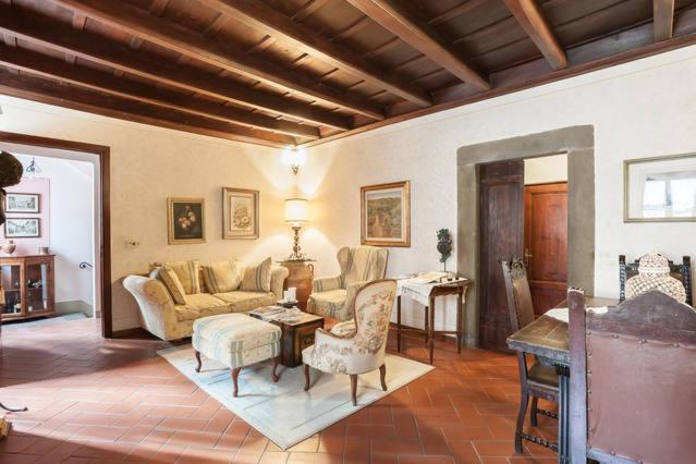 sala de estar con sofá y mesa en LA FINESTRA SUL BORGO Dimora Storica, en Laterina