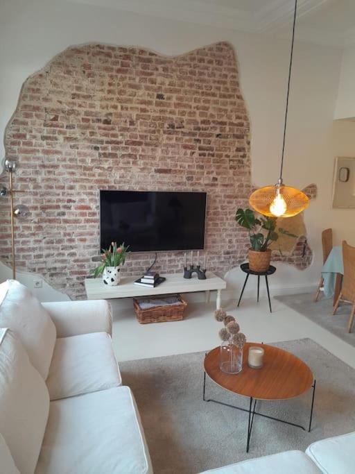 uma sala de estar com um sofá e uma parede de tijolos em charmante alte Stadtvilla em Epe