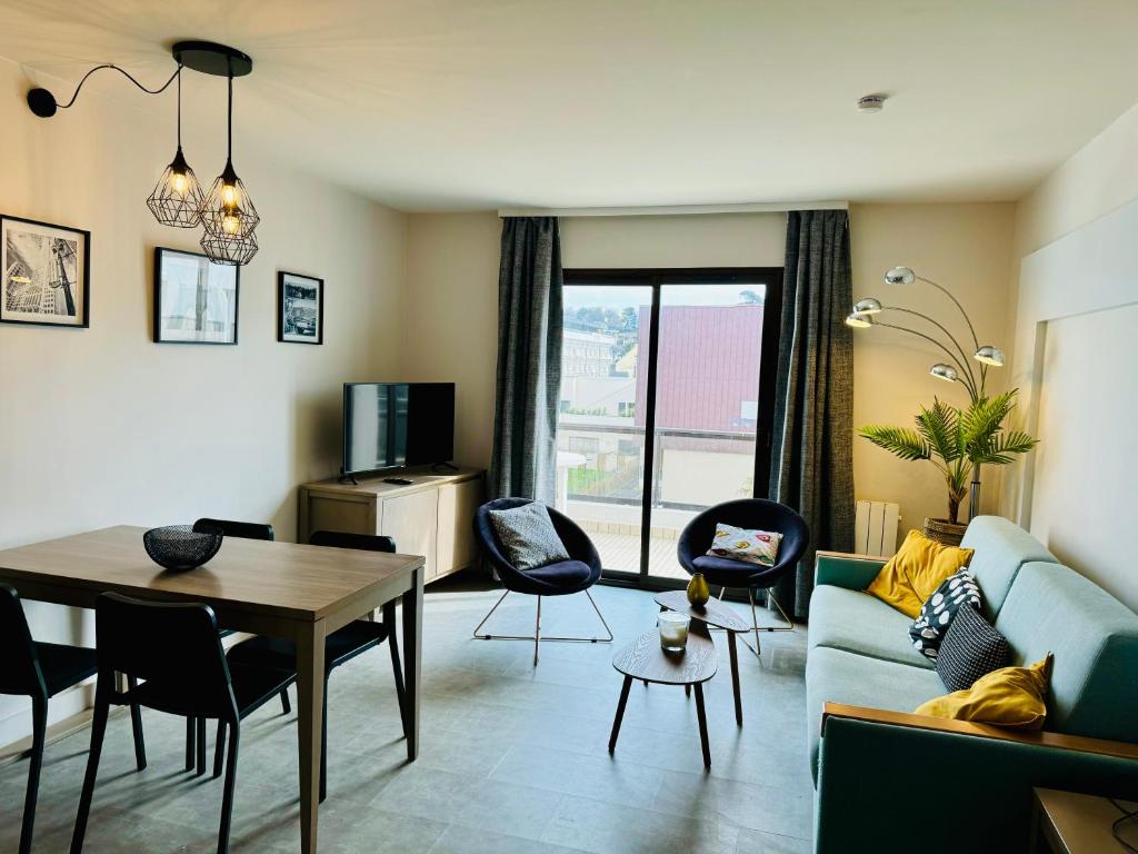 sala de estar con sofá azul y mesa en appartement vue mer 50m de la plage, WIFI gratuit en Perros-Guirec