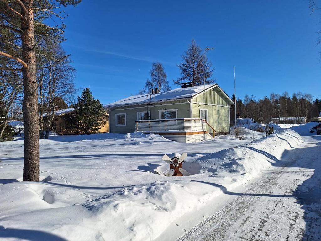 a fire hydrant covered in snow in front of a house at Villa Lumia in Paranen