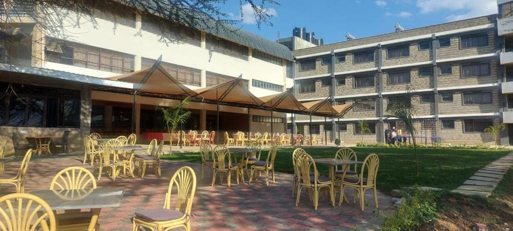 a patio with tables and chairs in front of a building at Lysak Haven Park hotel in Machakos