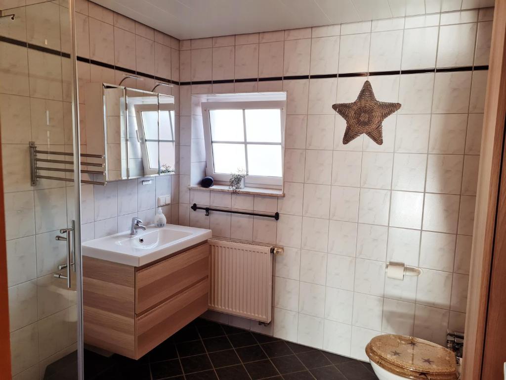 a bathroom with a sink and a star on the wall at Ferienwohnung am Lutherweg 1521 in Breitenbach am Herzberg