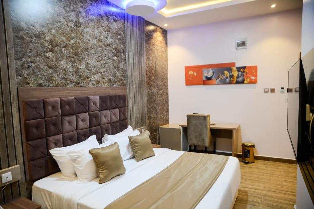 a hotel room with a bed and a desk at THE KINGSLEY La -PRIMA CASA HOTEL in Lagos