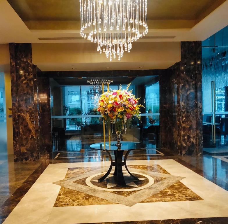 a lobby with a table with a vase of flowers at Ivy Thonglor in Khlong Toei