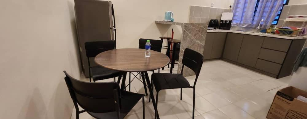 - une cuisine avec une table et des chaises dans la chambre dans l'établissement Hayyan Homestay, à Kuantan
